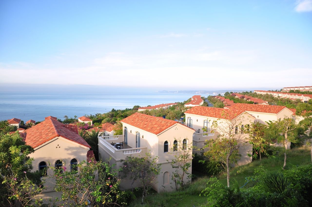 Beautiful Mediterranean villas overlooking a tranquil sea under clear skies.