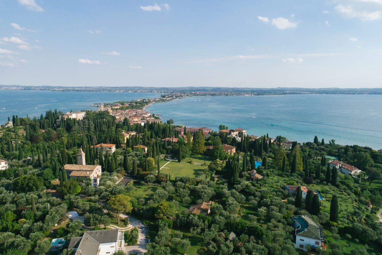 Crafting Captivating Headlines: Your awesome post title goes here A lush aerial view of a picturesque lakeside town in Italy, surrounded by greenery and the serene lake waters.